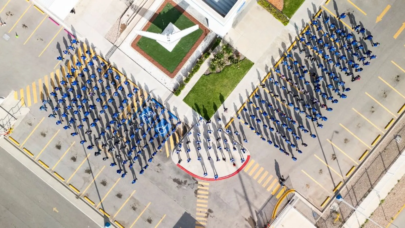 Vista aérea del personal de una planta formado en el estacionamiento