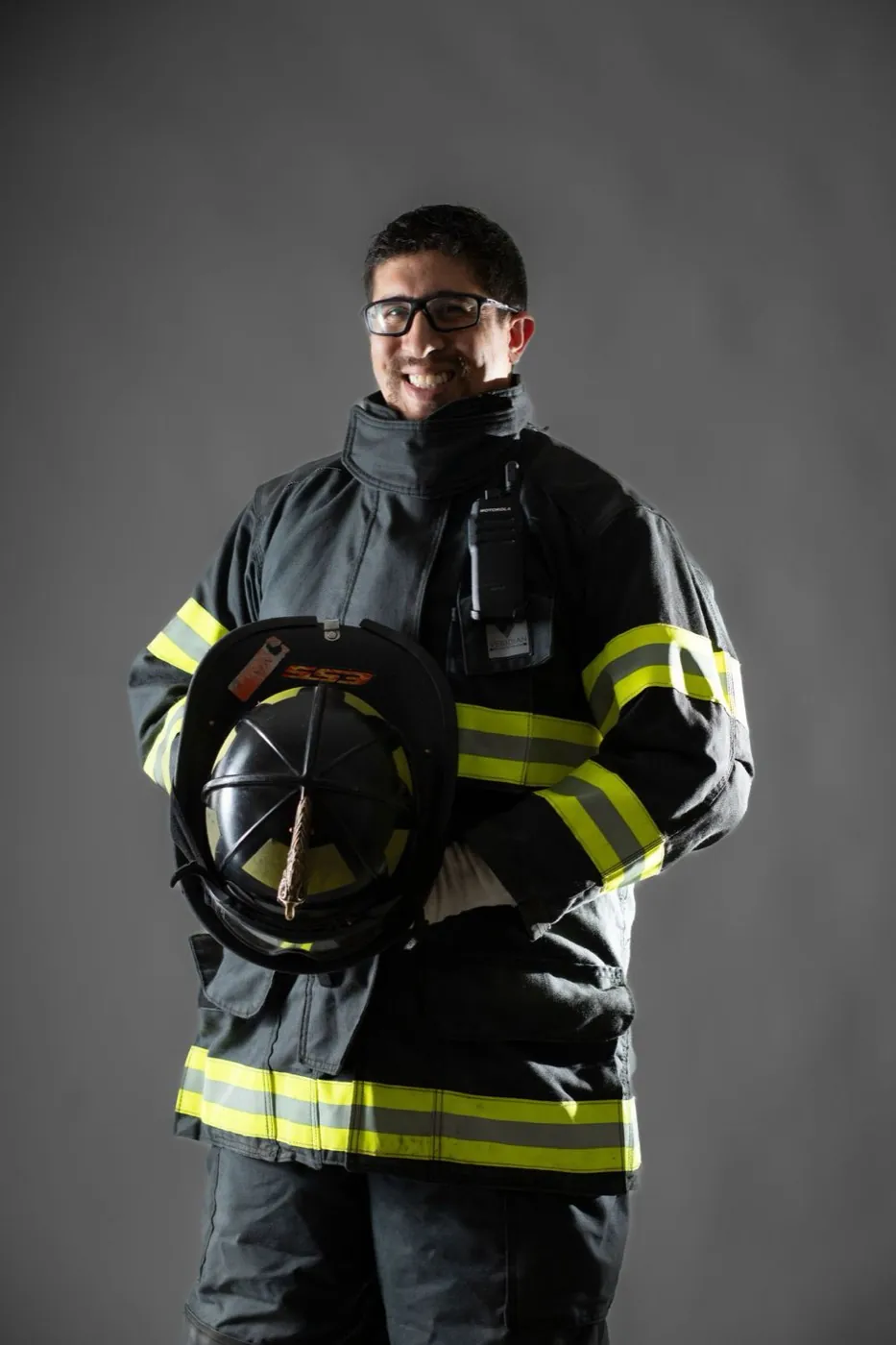 Retrato de estudio de un bombero industrial sosteniendo su casco